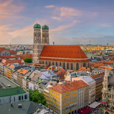 Blick auf die Frauenkirche und umliegenden Gebäude beim Sonnenuntergang.