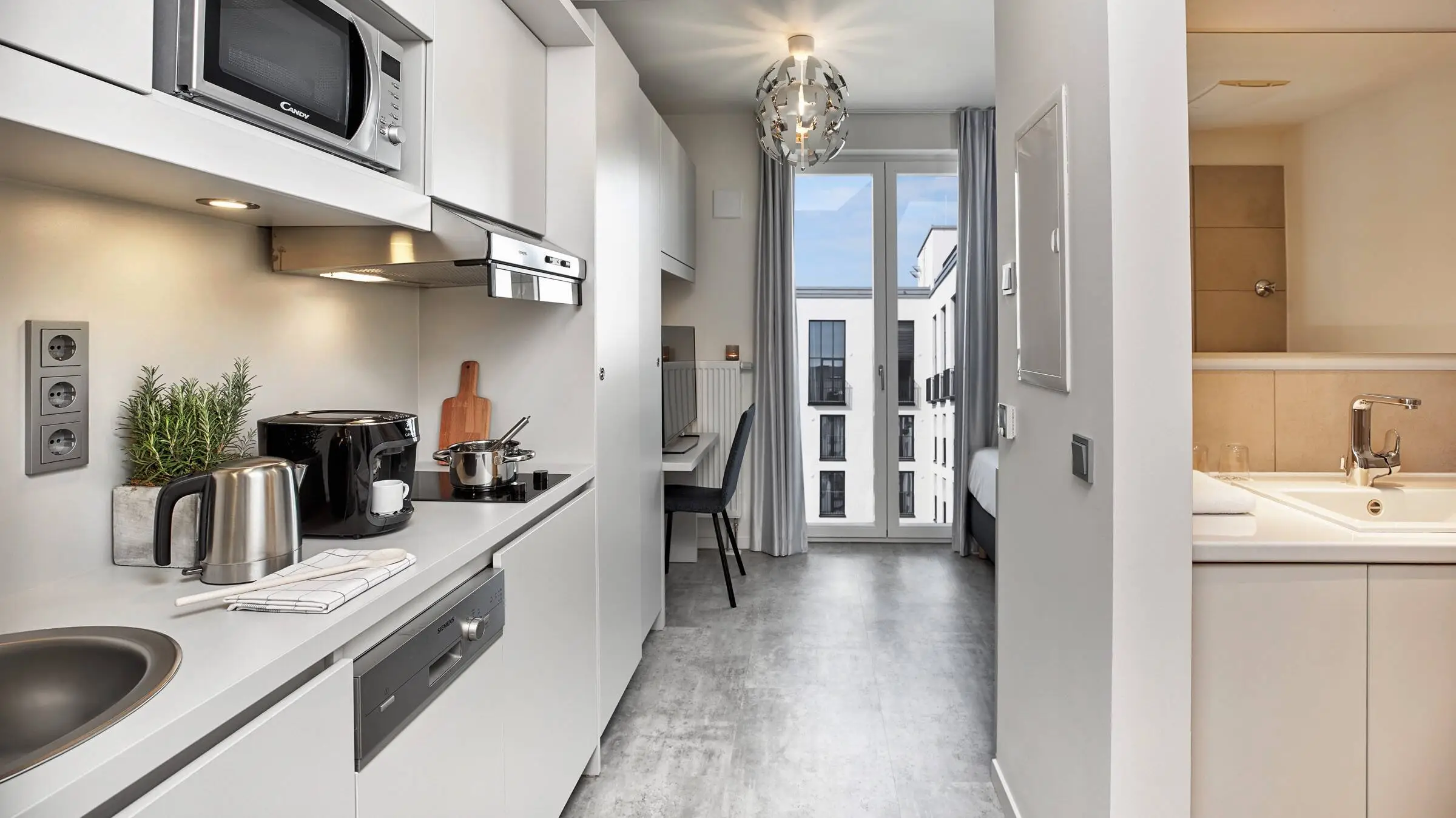 View of a flat with a small, fully functional fitted kitchen on the left.
