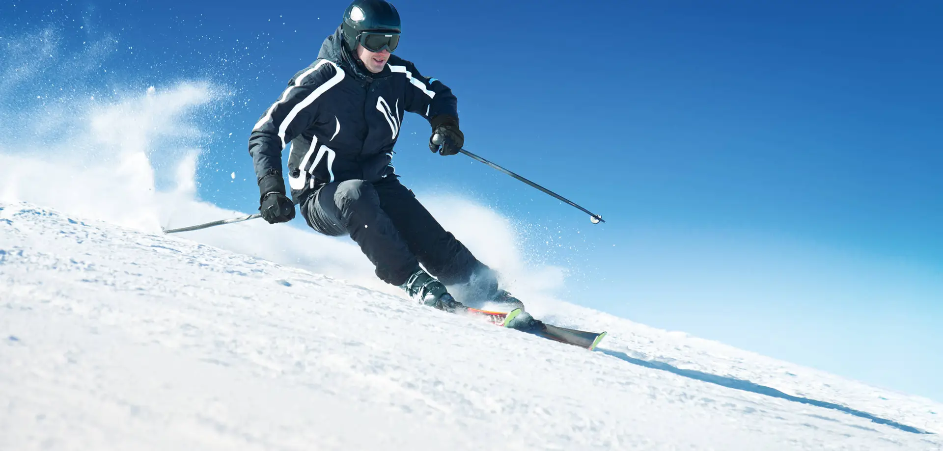 Ein Skifahrer fährt einen Berg runter.