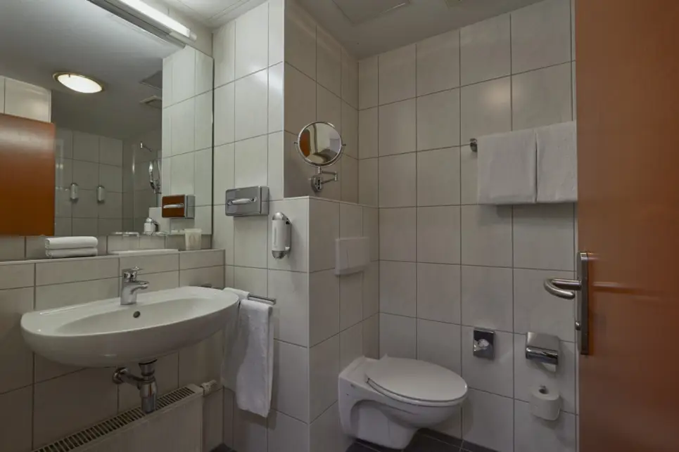 Badezimmer mit einem Waschbecken auf der linken Seite und einer Toilette auf der rechten Seite.