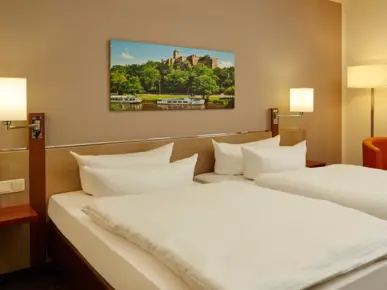 Doppelbett mit Nachttisch und einem Sessel neben den Bett. 