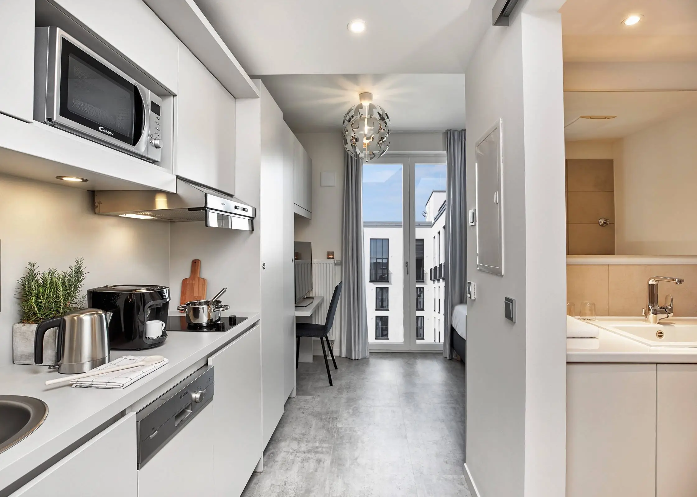View of a flat with a small, fully functional fitted kitchen on the left.