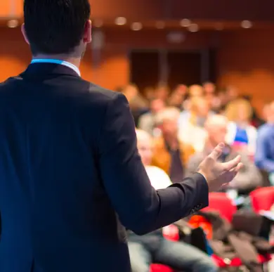View from behind of a man in a business outfit. In front of him a large room with many people. View from behind of a man in a business outfit. In front of him a large room with many people.