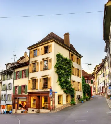 Kreuzung in der Altstadt von Basel, in der Mitte ein gelbes Haus