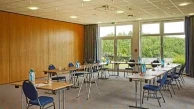 Tagungsraum in Willingen Tagungsraum mit UForm-Bestuhlung. Vor dem Fenster ist ein großer Wald.