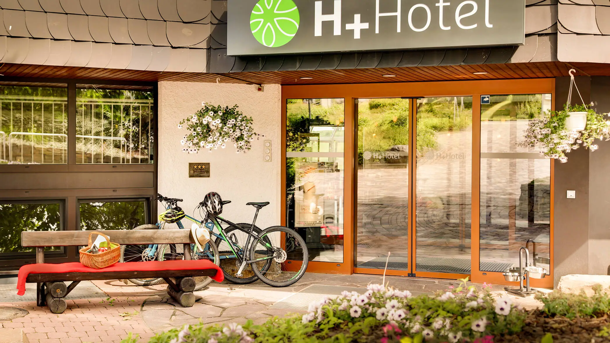Entrée de l'hôtel H+ Hotel Willingen avec des vélos.