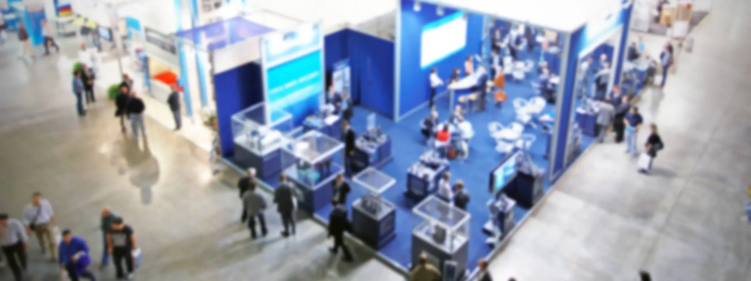 Viele Menschen im ANzug stehen in einer großen Halle.