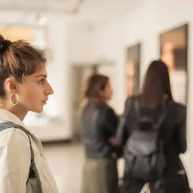 Drei Frauen betrachten Bilder in einer Galerie