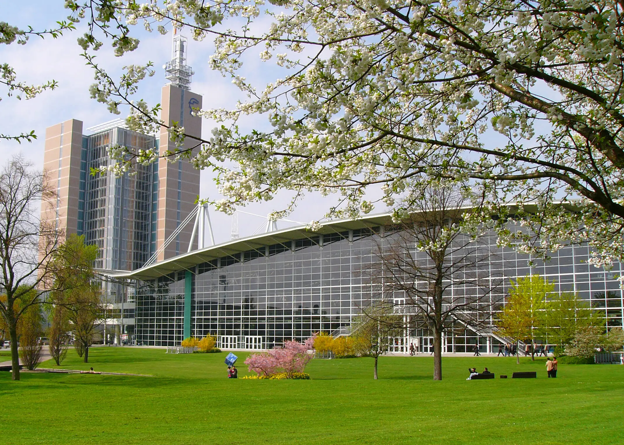 View across a lawn to a building at Hannover Messe with large windows.