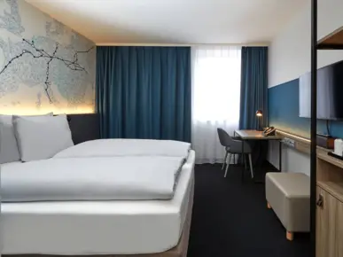 Hotelzimmer mit einem Doppelbett und einem Bild darüber.