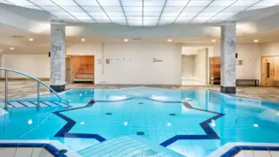 Sternförmiger Pool im hellen Schwimmbad vom Hotel.