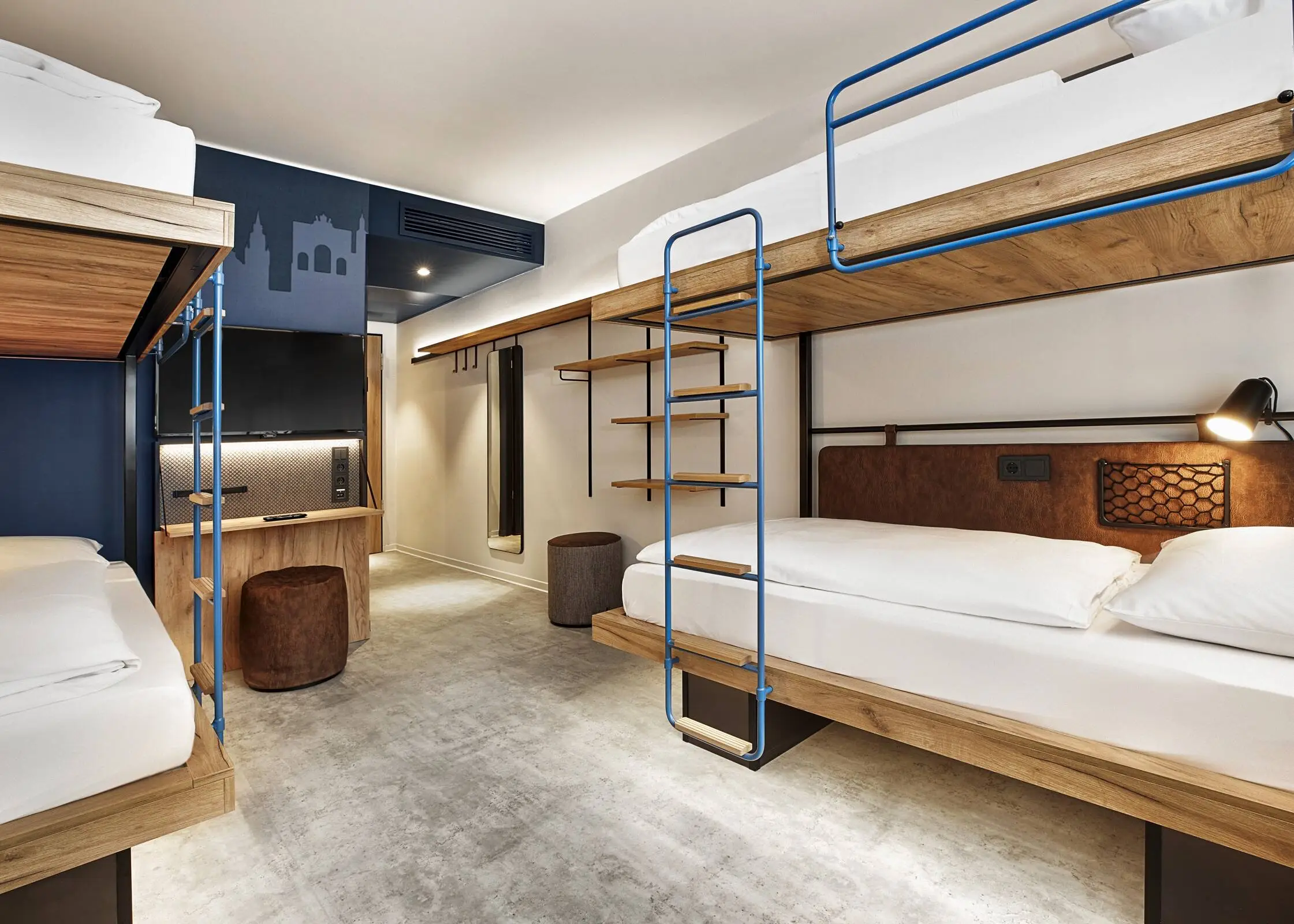Chambre d'hôtel avec lits superposés. La chambre est décorée dans des tons bleu foncé et marron.