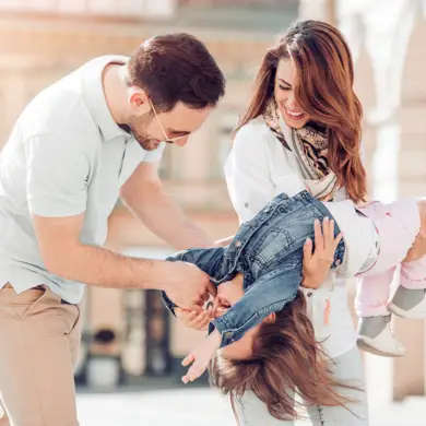 Unos padres tontean con su hija durante un paseo