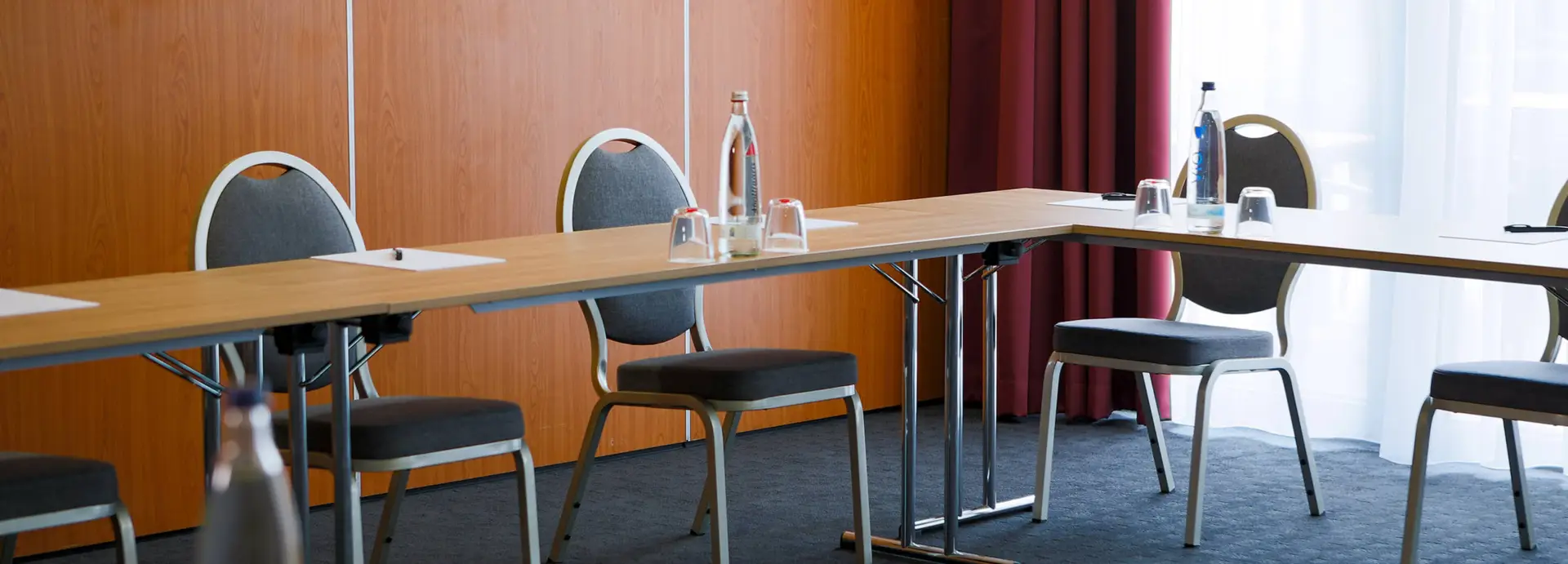 Detailaufnahme von Konferenztischen mit Stühlen.