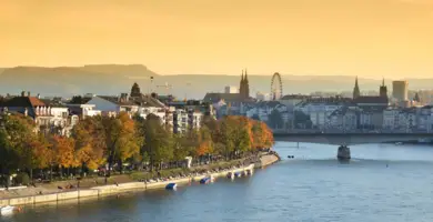 Blick über den Rhein auf die Basler Skyline während des Sonnenaufgangs.