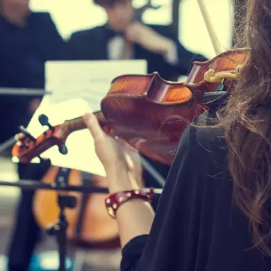 Achteraanzicht van een viool bespeeld door een violist