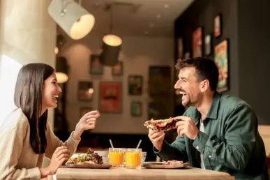 Silvester in Paris Ein Paar sitzt beim Frühstück und lacht.