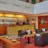Lobby mit Sesseln und einer Couch. Im Hintergrund steht die goldene Rezeption.
