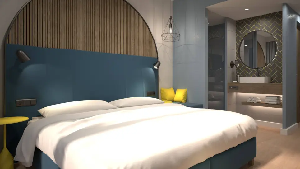 Chambre d'hôtel avec un lit double et une salle de bain semi-ouverte. 