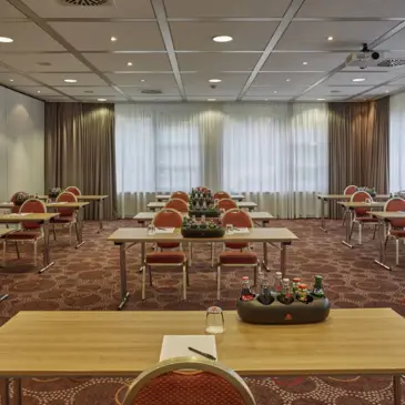 Tagungsraum mit Blockbestuhlung. Blick vom Rednertisch aus.
