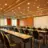 Sala de conferencias con grandes ventanales y muchas filas de sillas.