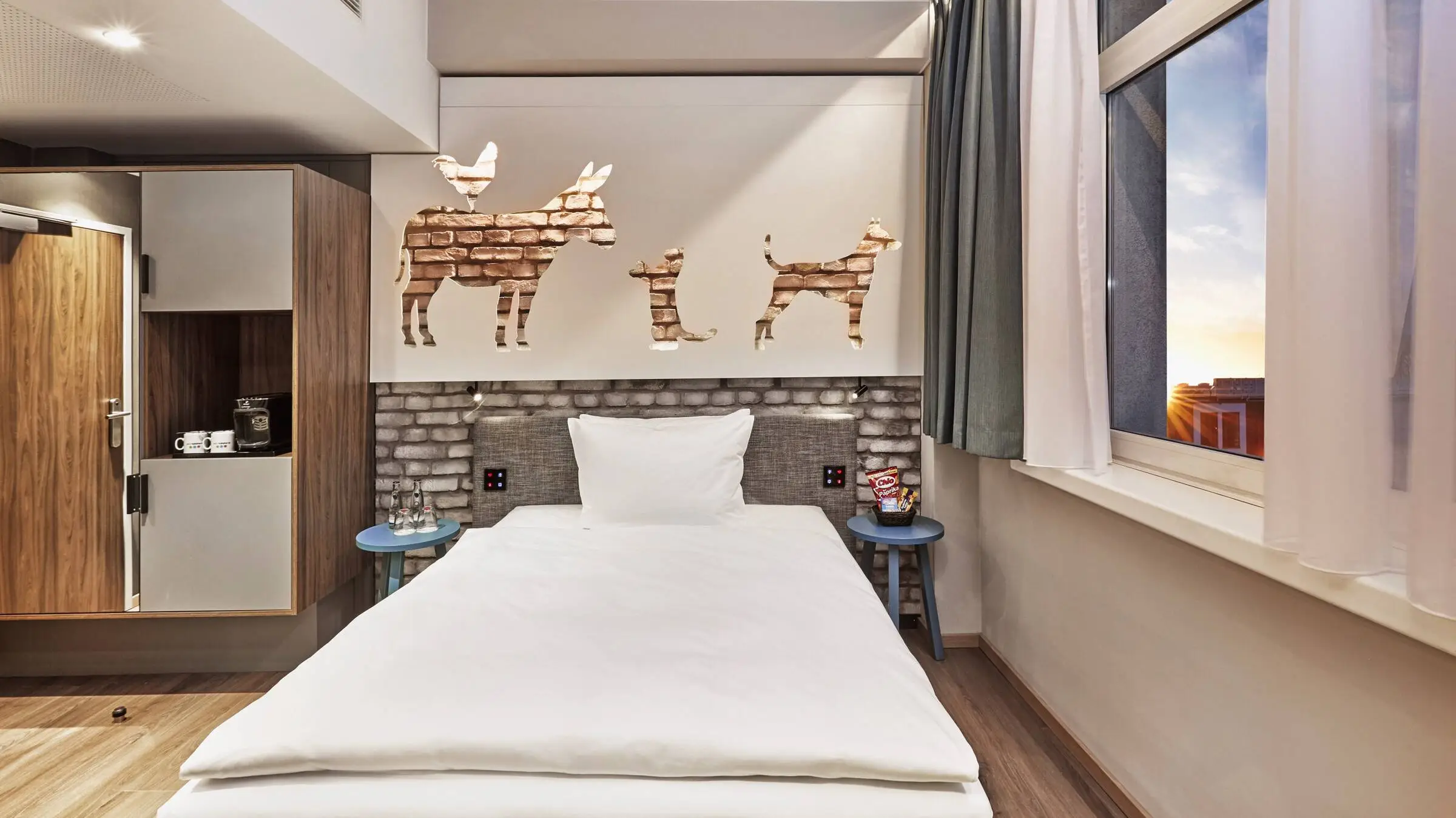 Single bed in the hotel room. Above the bed are the Bremen Town Musicians.