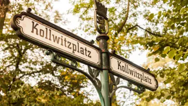 Altes Straßenschild auf dem Kollwitzplatz steht.
