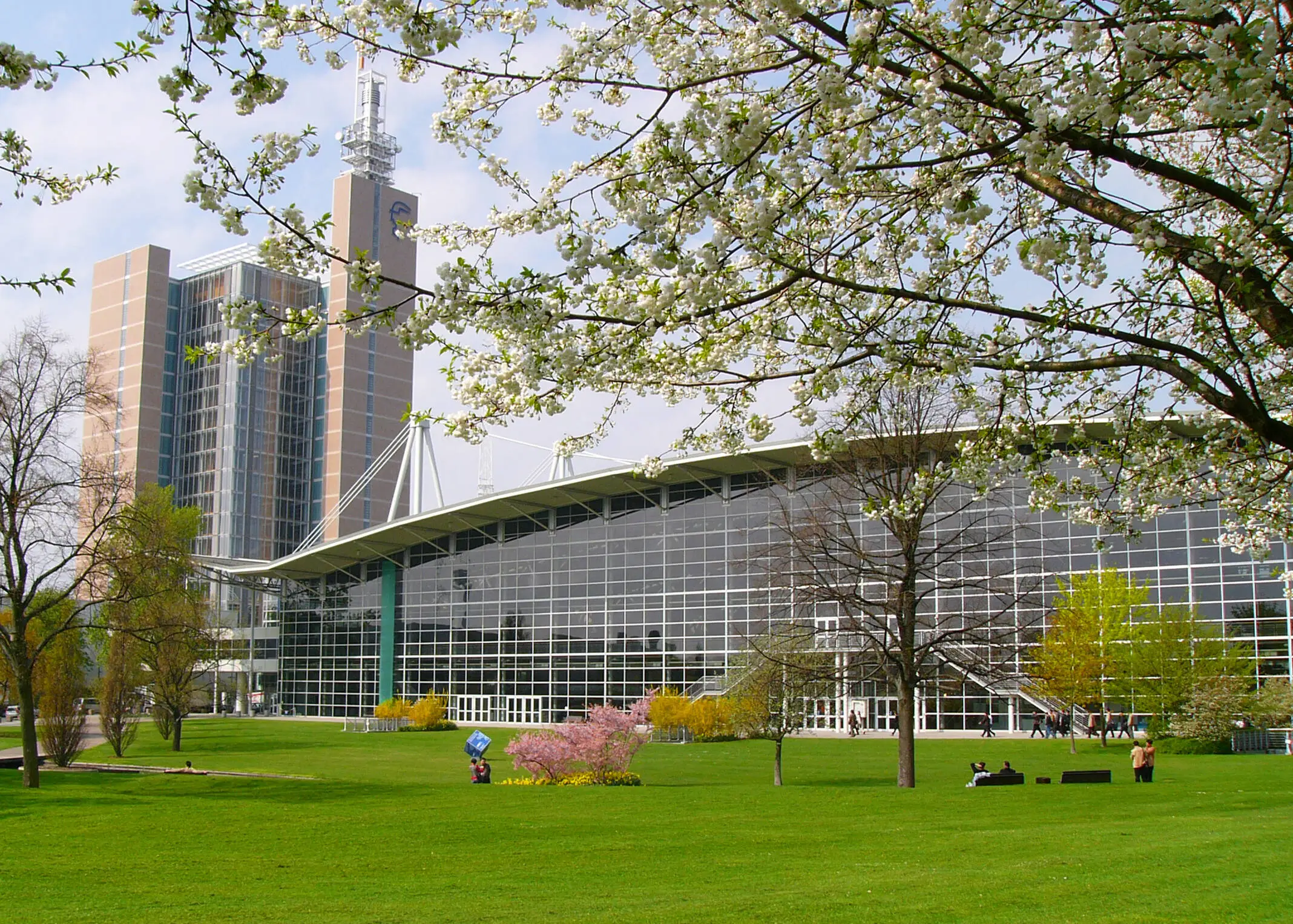 Blick über eine Rasenfläche auf ein Gebäude der Hannover Messe mit großer Fensterfront.