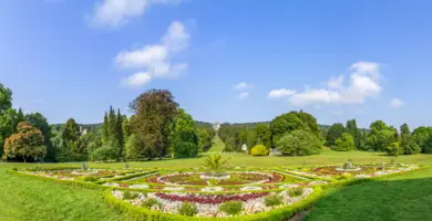 Parkanlage mit runden Blumenbeeten.