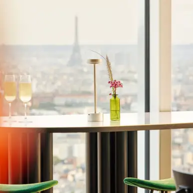 Bar de l'hôtel avec de grandes fenêtres et vue sur Paris.