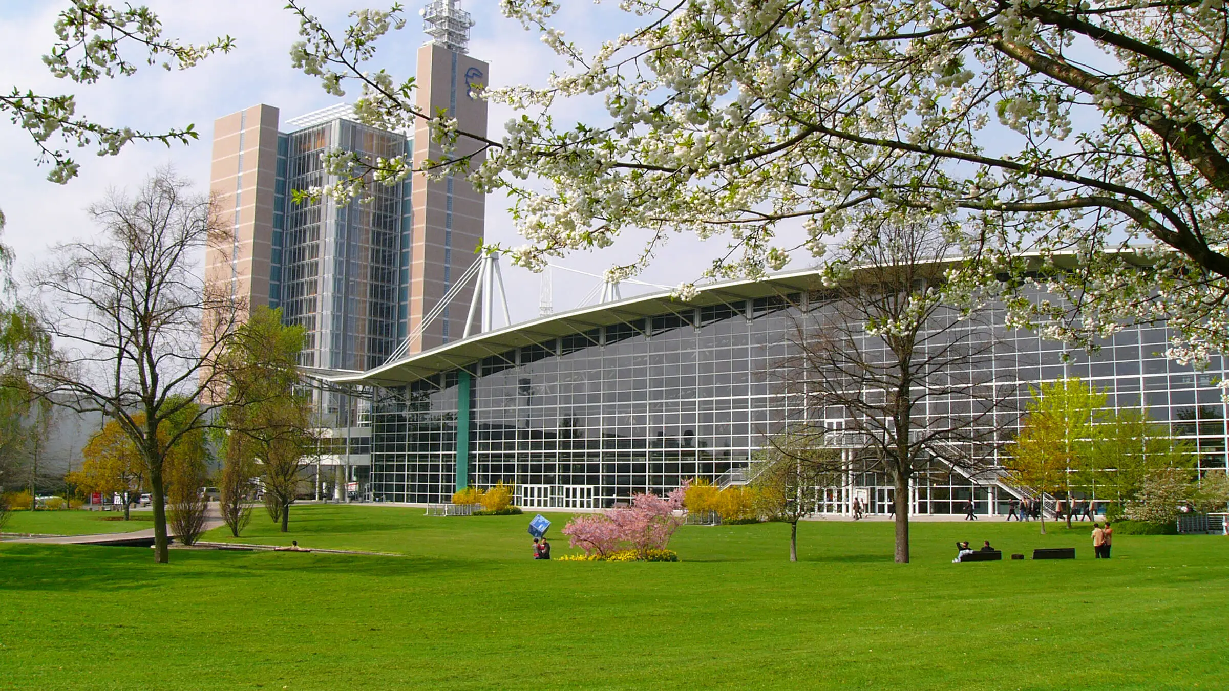 View across a lawn to a building at Hannover Messe with large windows.