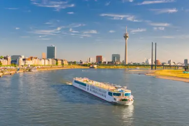 Ausflugsschiff fährt auf dem Rhein. Im Hintergrund befindet sich der Rheinturm. Ausflugsschiff fährt auf dem Rhein. Im Hintergrund befindet sich der Rheinturm.