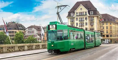 Grüne Straßenbahn fährt auf einer Brücke.