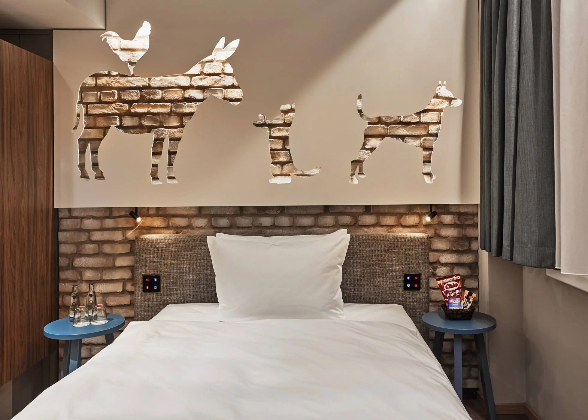 Einzelbett im Hotelzimmer. Über dem Bett sind die Bremerstadtmusikanten.