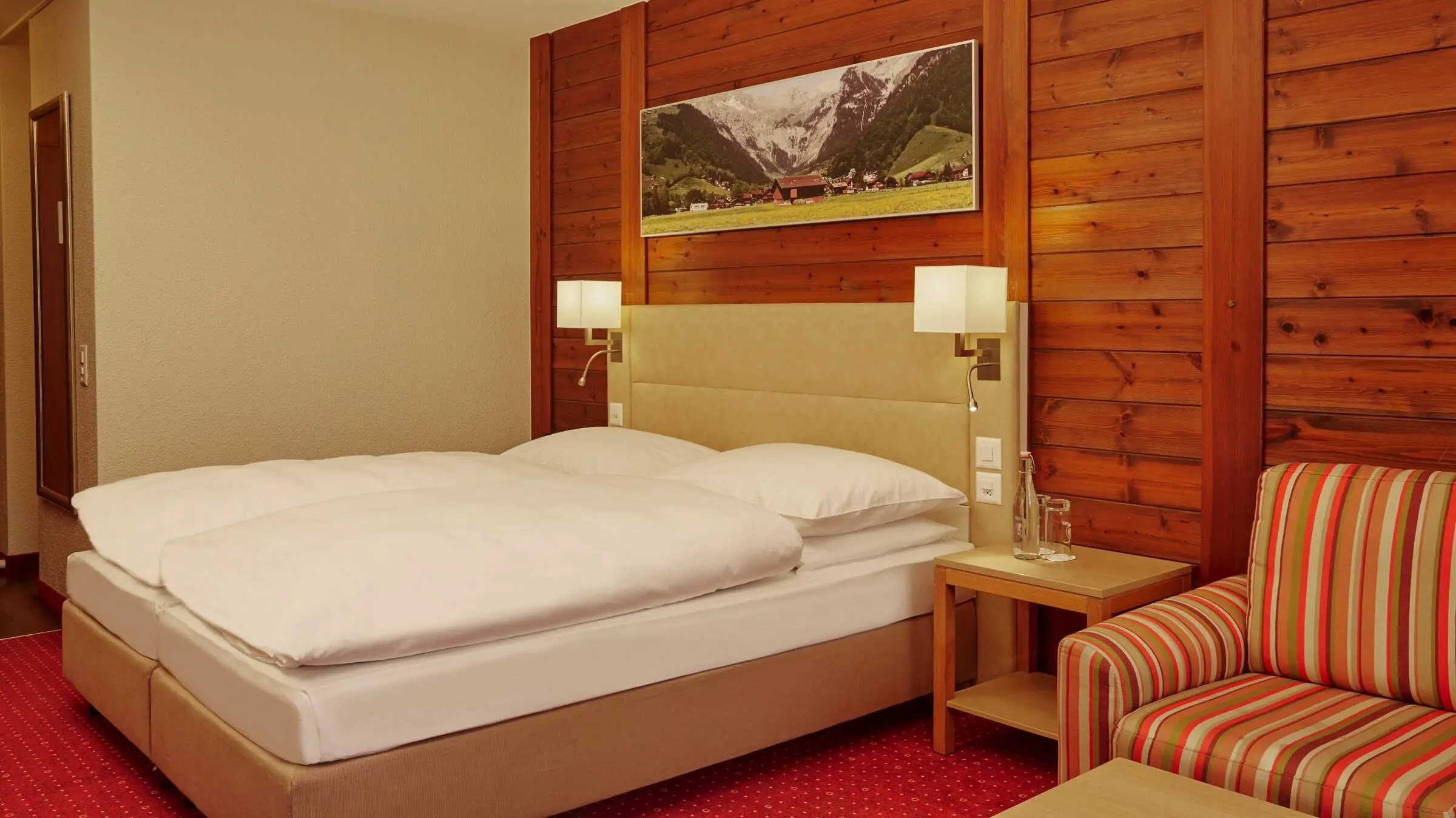Hotelzimmer im rustikalen Stil mit Holzwänden.