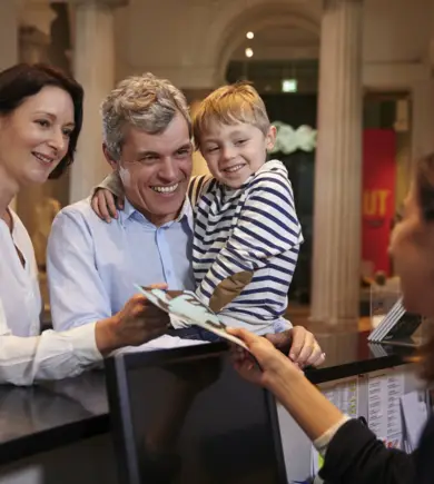 Familie bezoekt een museum en staat bij de kassa