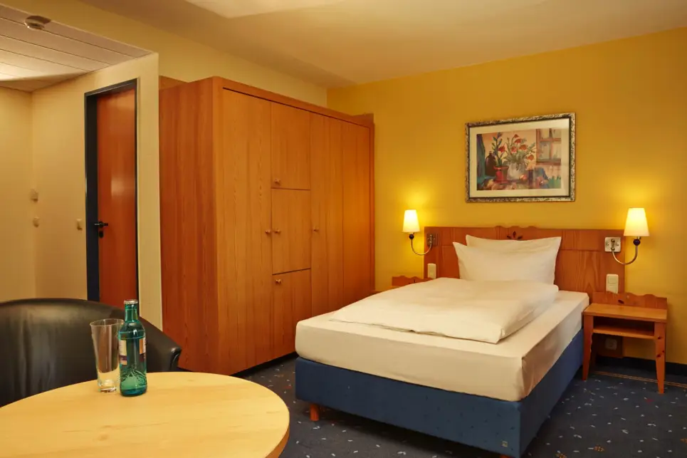 Habitación Habitación de hotel con una cama individual y un gran armario al lado.