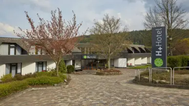 Tagungen im H+ Hotel Willingen Auffahrt vom Hotel mit dem Eingangsbereich im Hintergrund.