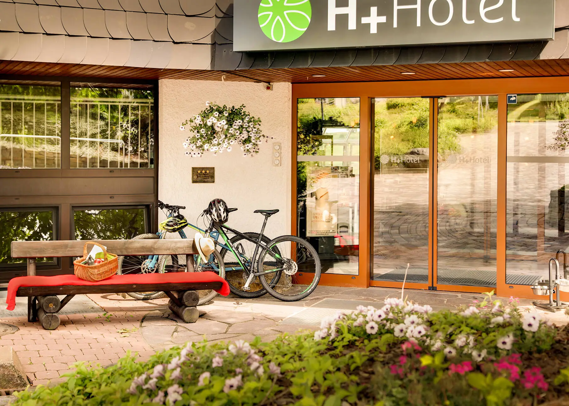 Entrée de l'hôtel H+ Hotel Willingen avec des vélos.