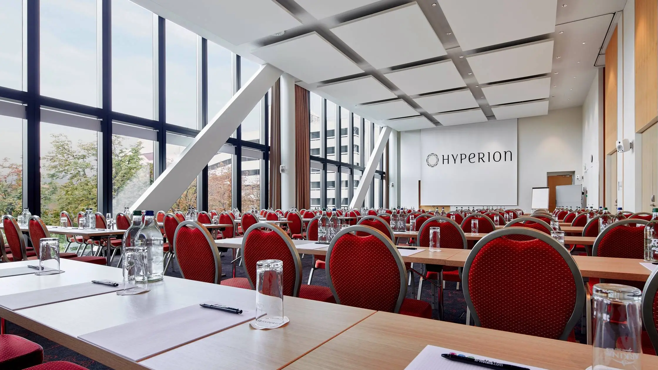 Grande salle de conférence avec de grandes fenêtres de l'hôtel HYPERION Hotel Basel..
