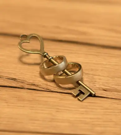 Alter, goldener Schlüssel, auf dem zwei goldene Ringe stecken.