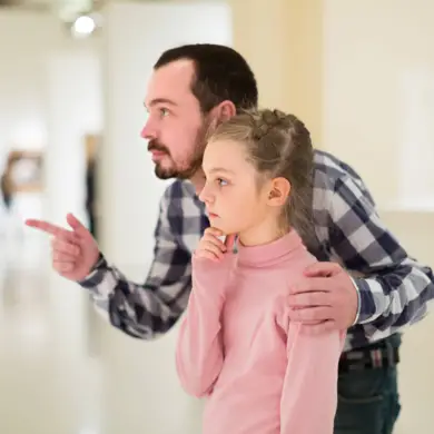 Il padre spiega un'immagine alla figlia e la indica