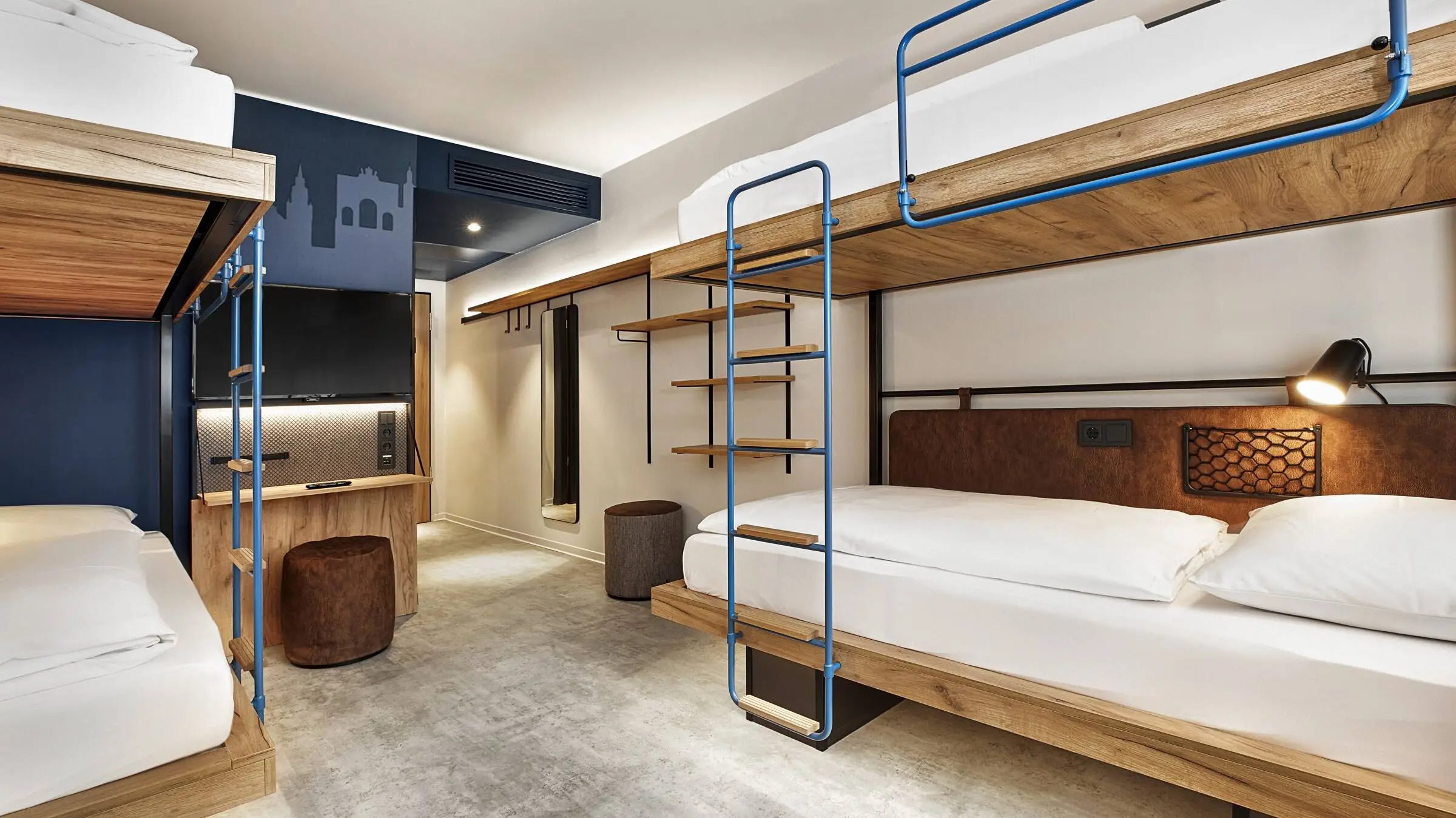 Habitación de hotel con literas. La habitación está decorada en tonos azul oscuro y marrón.