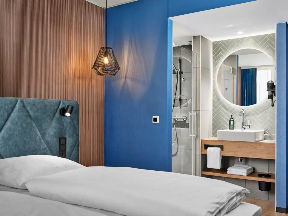 Hotel room with a double bed and a semi-open bathroom. 