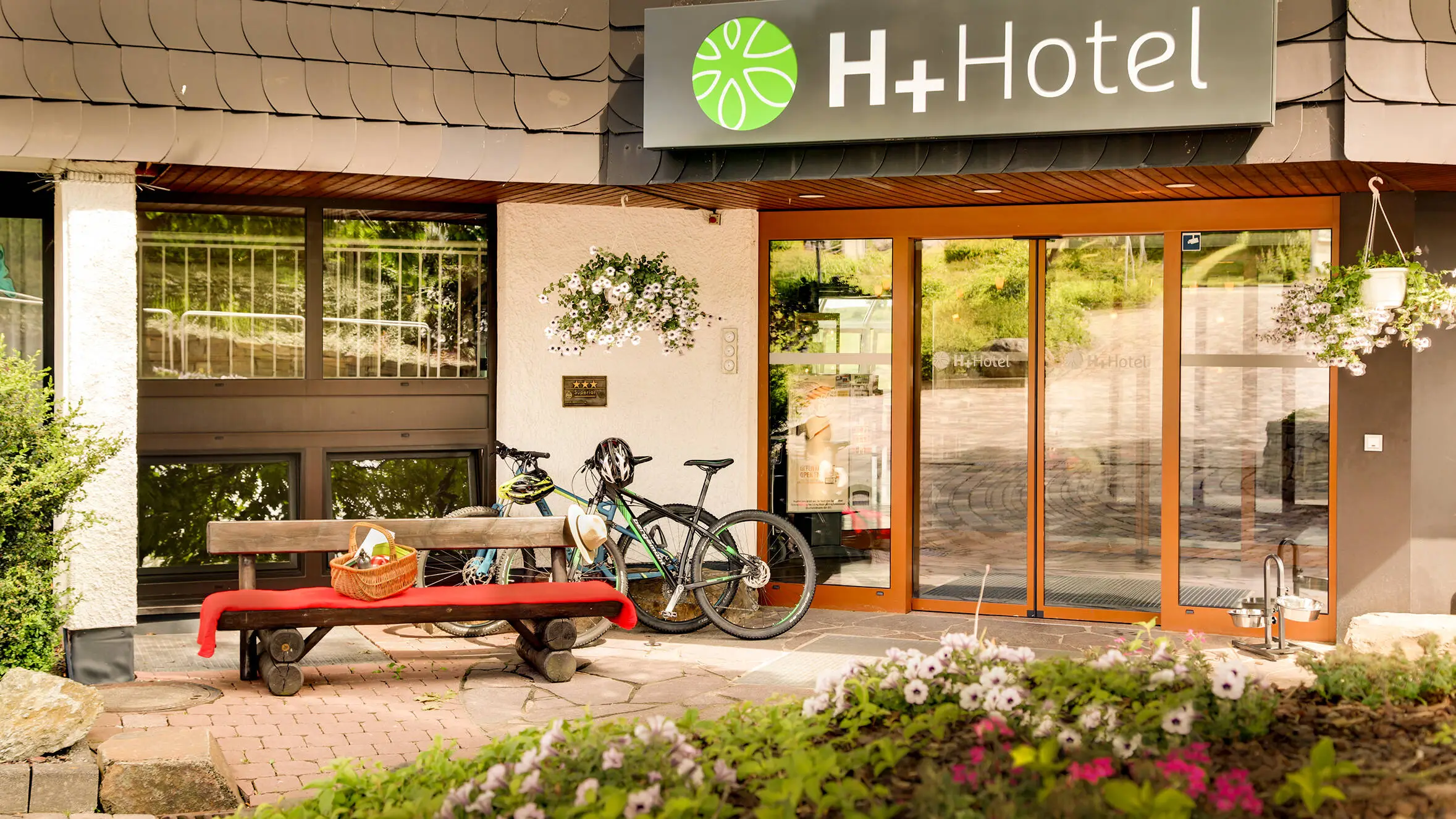 Entrée de l'hôtel H+ Hotel Willingen avec des vélos.