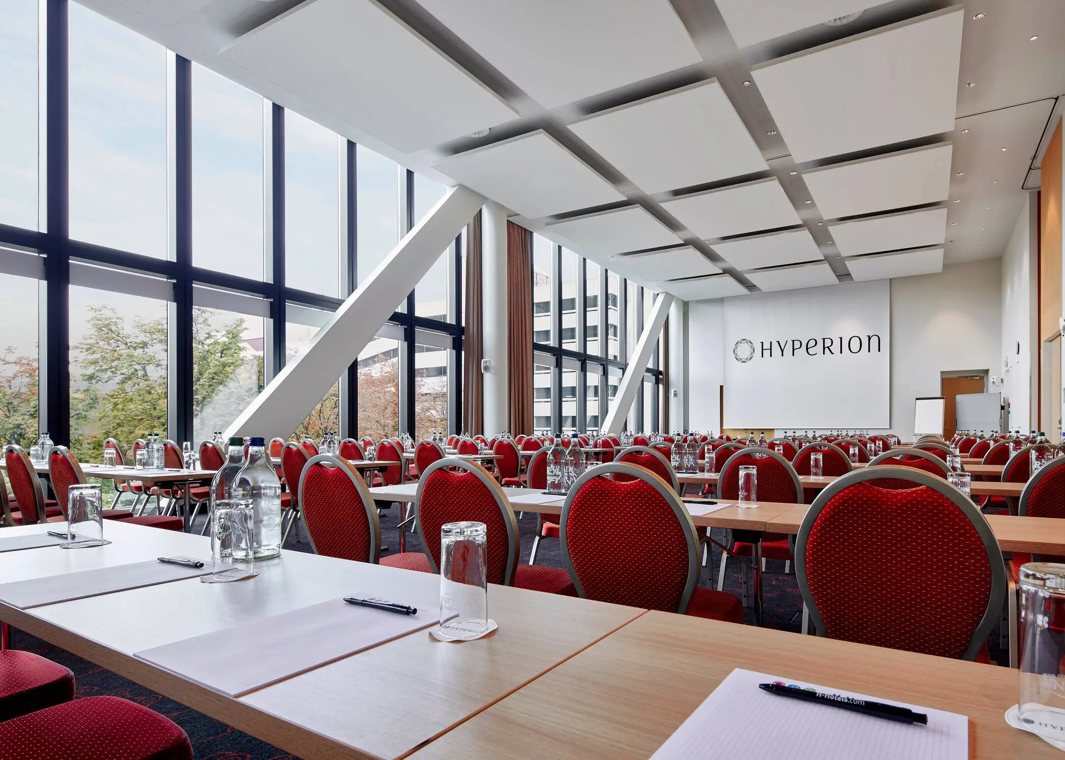 Grande salle de conférence avec de grandes fenêtres de l'hôtel HYPERION Hotel Basel..