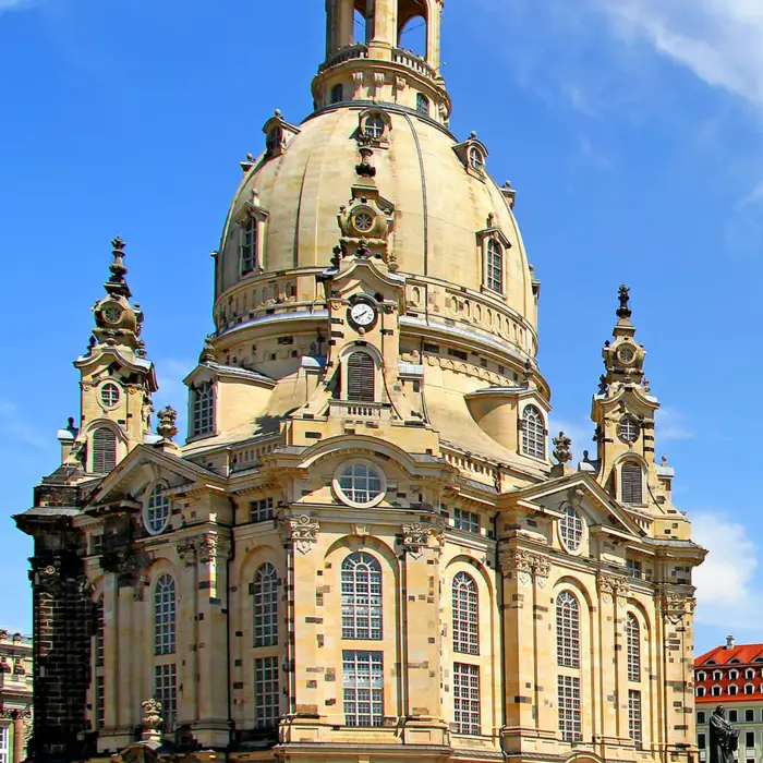 Dresdner Frauenkirche von vorn am Tag. Auf dem Platz vor der Kirche stehen viele Menschen.