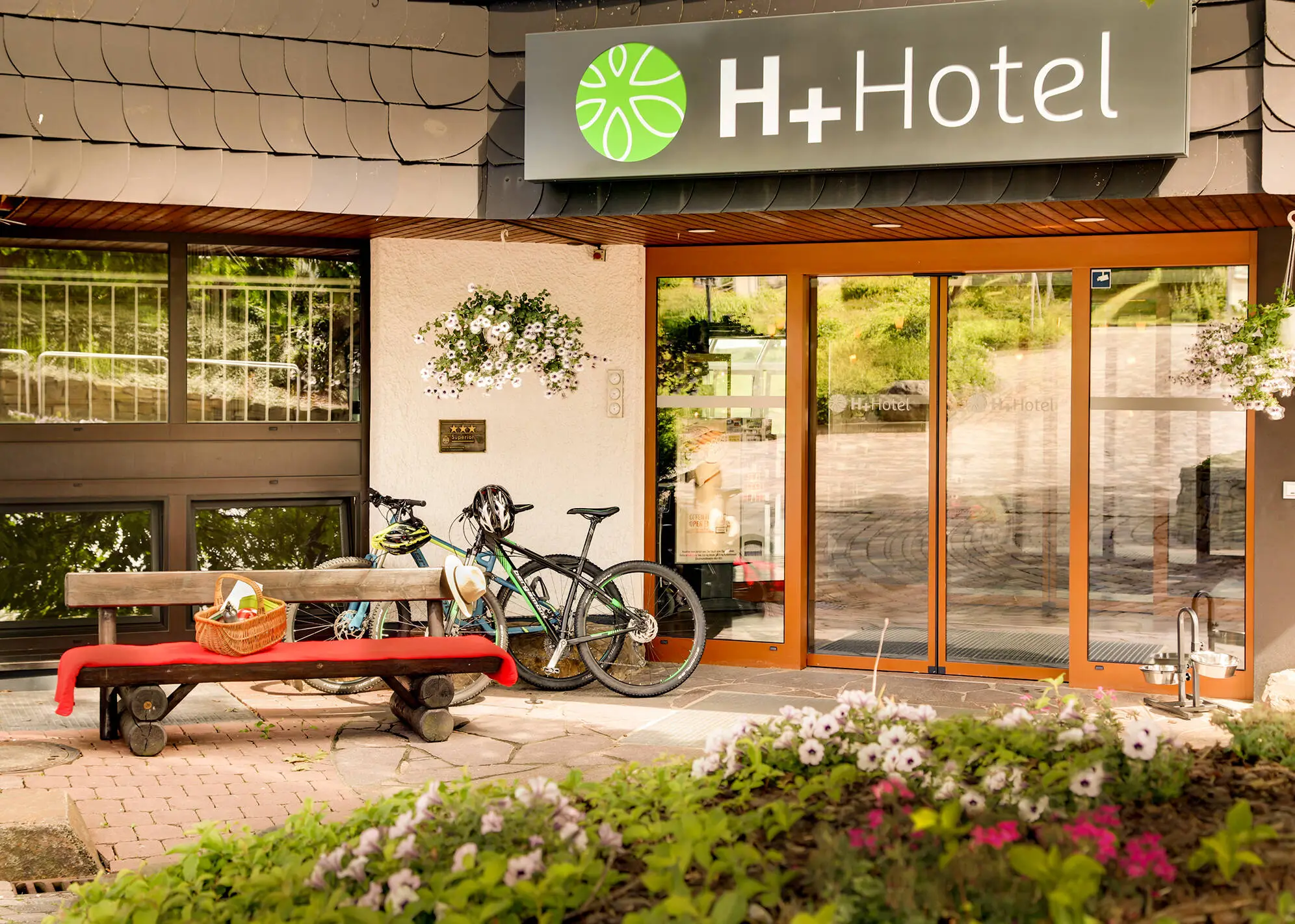 Entrée de l'hôtel H+ Hotel Willingen avec des vélos.