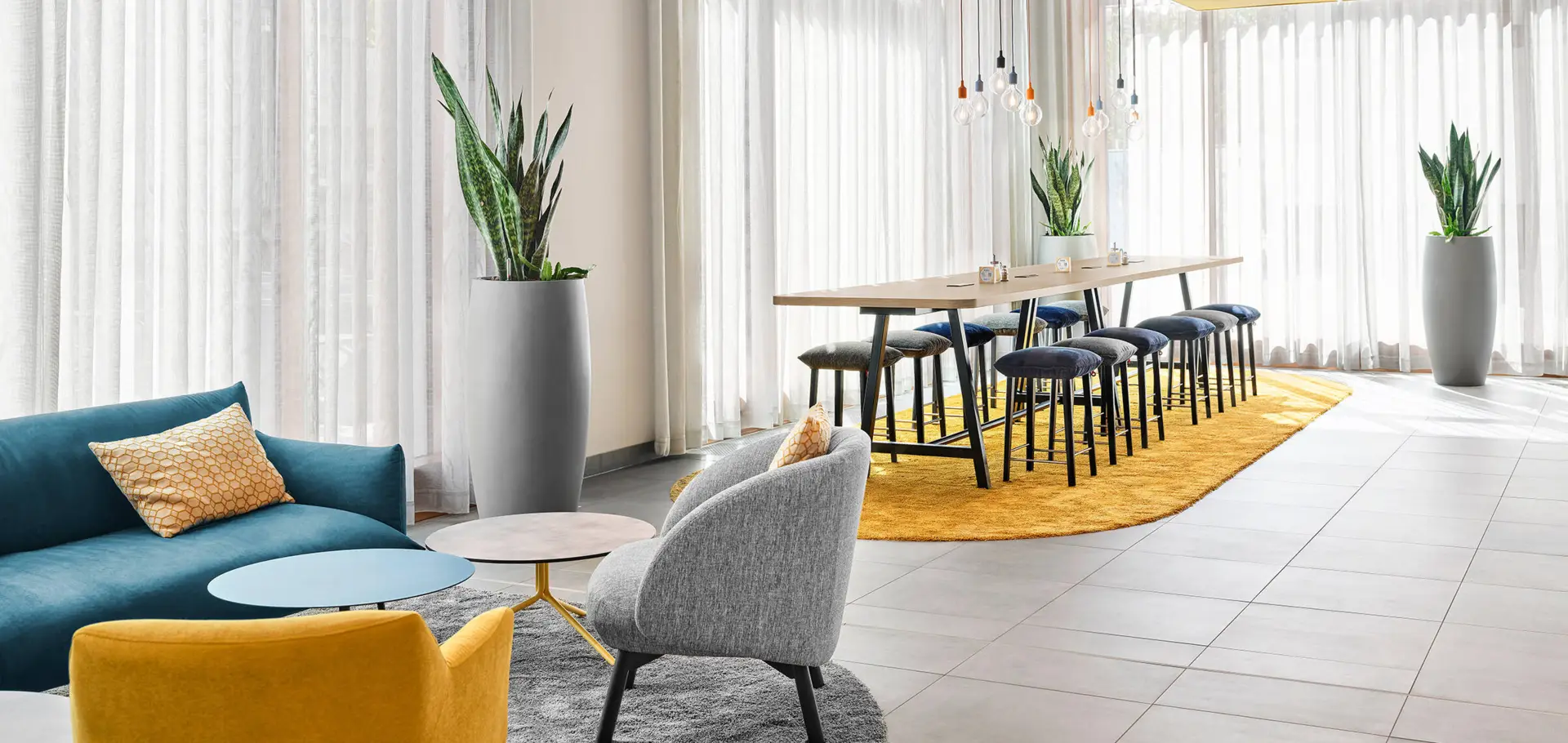 Lounge area in the hub with sofa, armchairs and chairs with large table.