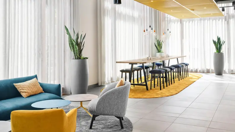 Zona de estar en el centro con sofá, sillones y sillas con mesa grande.